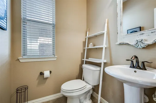 a bathroom with a sink a toilet and a window