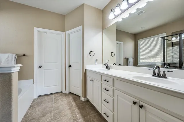 a bathroom with a double vanity sink mirror and toilet