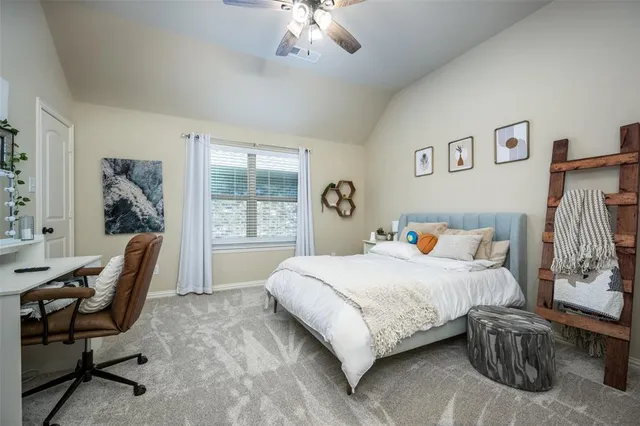 a bedroom with a bed a desk and chair with a bookshelf