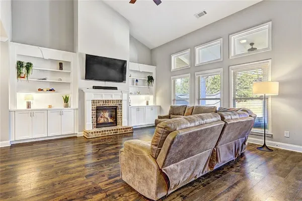 a living room with furniture a flat screen tv and a fireplace