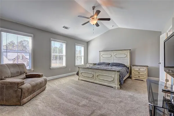 a bedroom with a bed a couch and a window