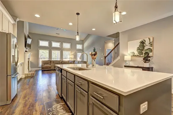 a kitchen with a refrigerator a sink and wooden floor