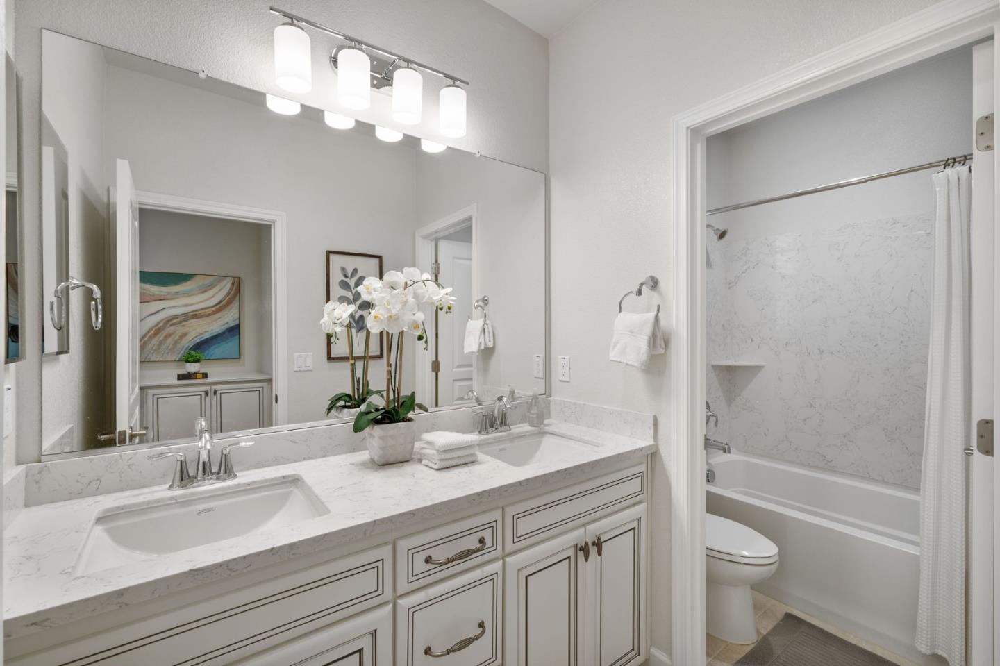 11958 Glaskin Place Dublin, CA 94568 - Photo 24 of 41 a bathroom with a granite countertop sink a toilet and a large mirror