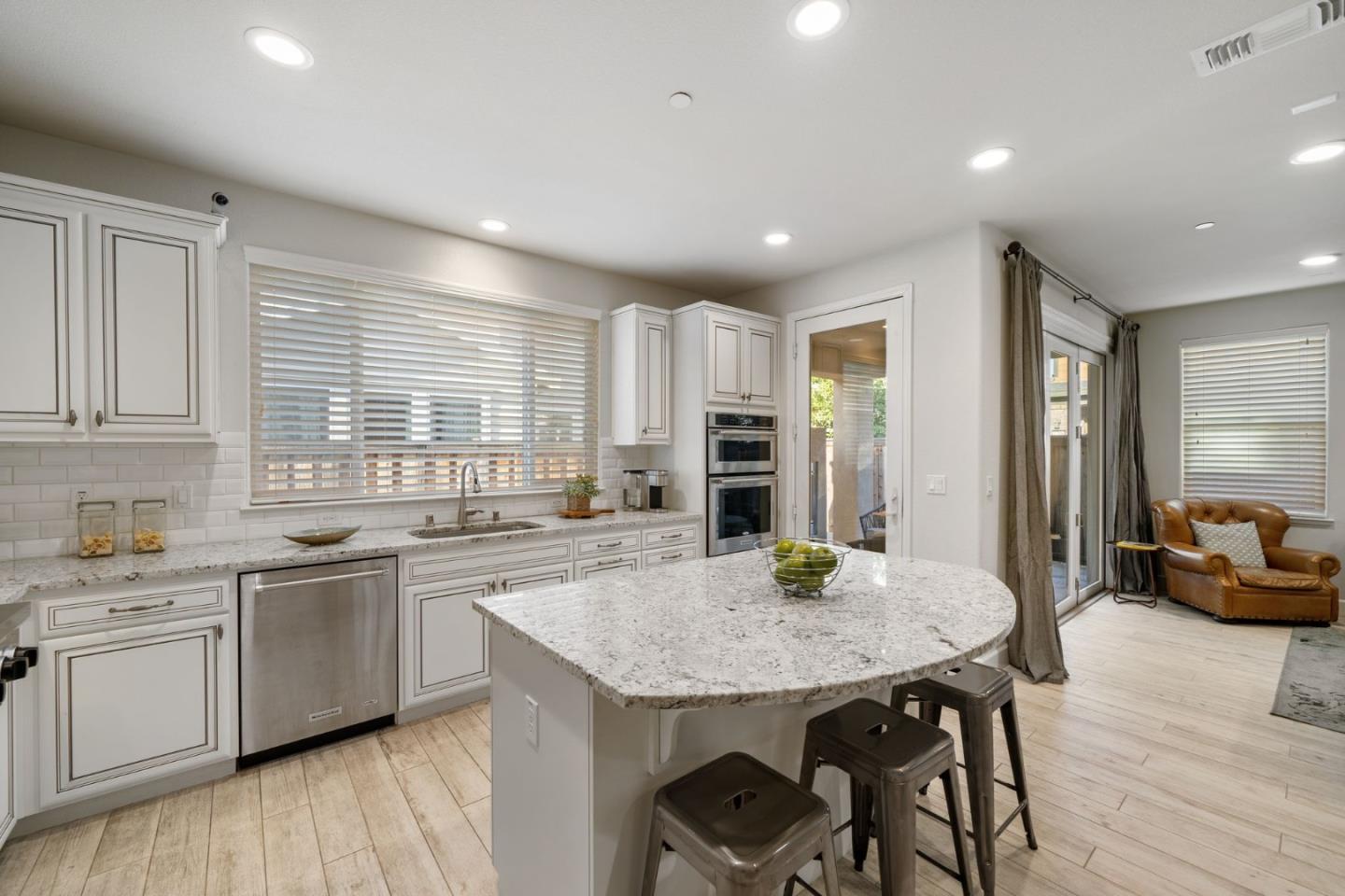 11958 Glaskin Place Dublin, CA 94568 - Photo 8 of 41 a kitchen with a sink a kitchen island and stainless steel appliances