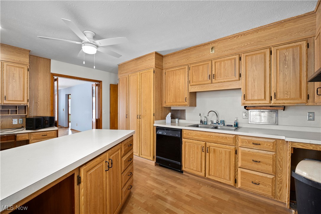 14015 West Lake Road Vermilion, OH 44089 - Photo 15 of 50 Kitchen featuring light countertops, dishwasher, a ceiling fan, light wood-style floors, and a textured ceiling