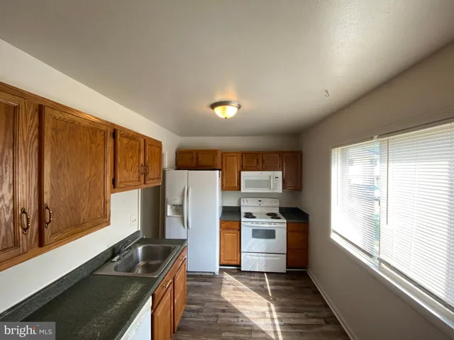 a kitchen with a refrigerator and a stove top oven