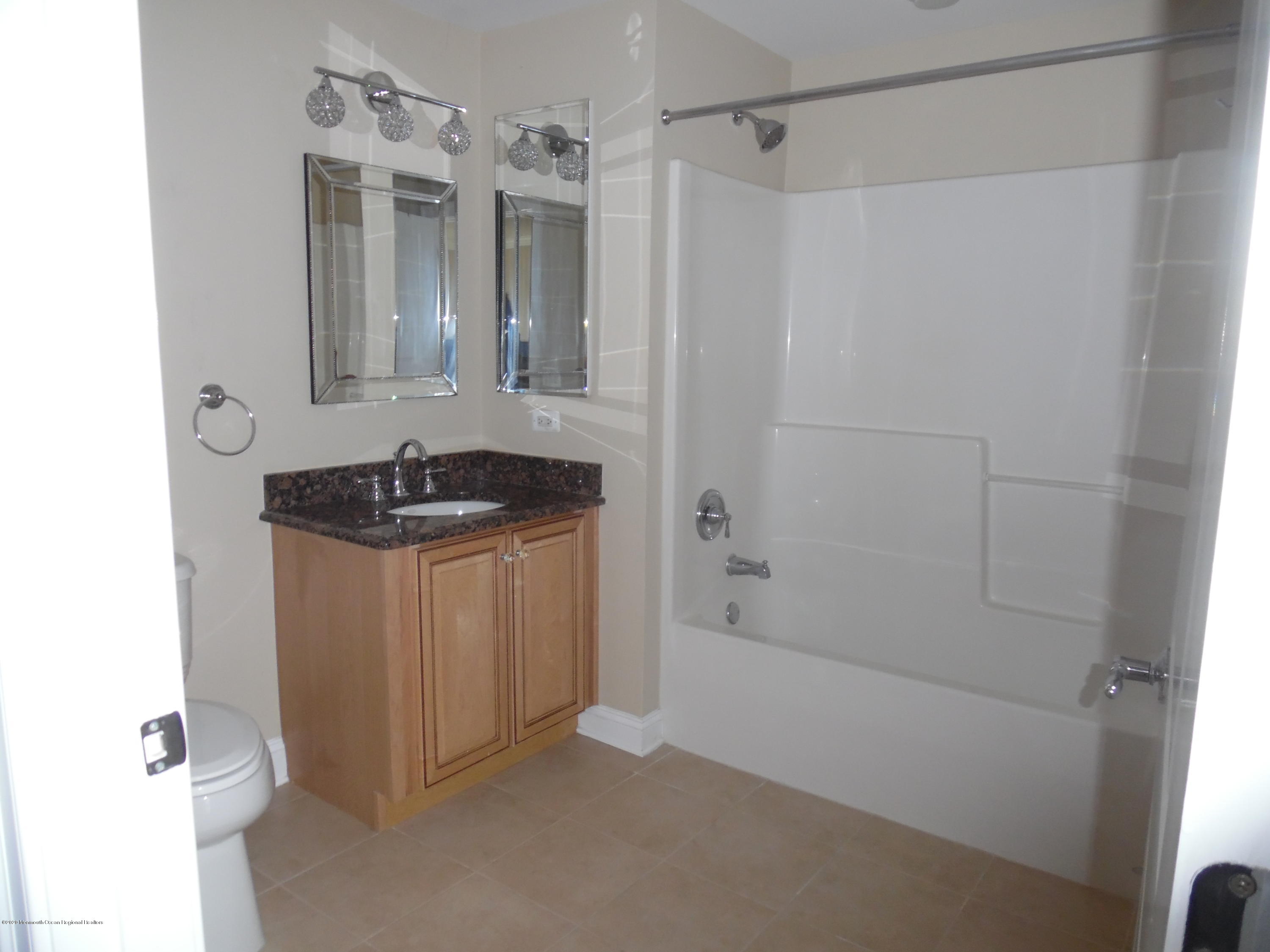 2201 River Road, Unit 2203 Point Pleasant, NJ 08742 - Photo 3 of 23 a bathroom with a granite countertop sink and shower