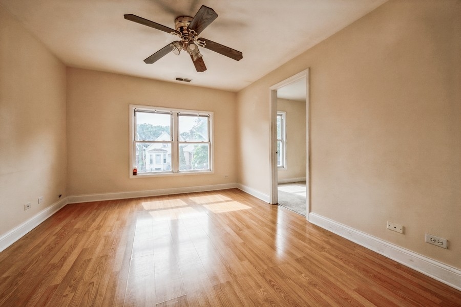 2139 North Kenneth Avenue Chicago, IL 60639 - Photo 12 of 21 a view of empty room with wooden floor and fan