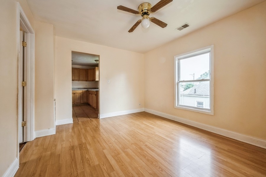 2139 North Kenneth Avenue Chicago, IL 60639 - Photo 15 of 21 a view of empty room with wooden floor and fan