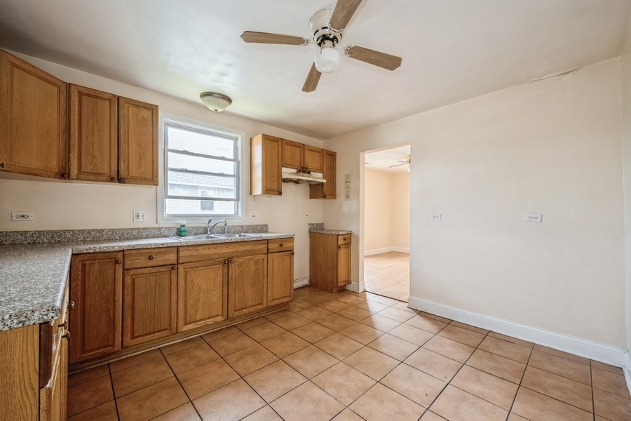 2139 North Kenneth Avenue Chicago, IL 60639 - Photo 18 of 21 a kitchen with granite countertop a sink cabinets stainless steel appliances and a window