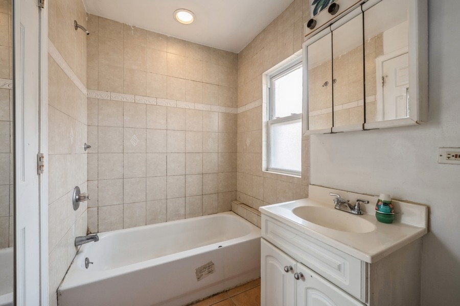 2139 North Kenneth Avenue Chicago, IL 60639 - Photo 19 of 21 a bathroom with a tub sink and mirror