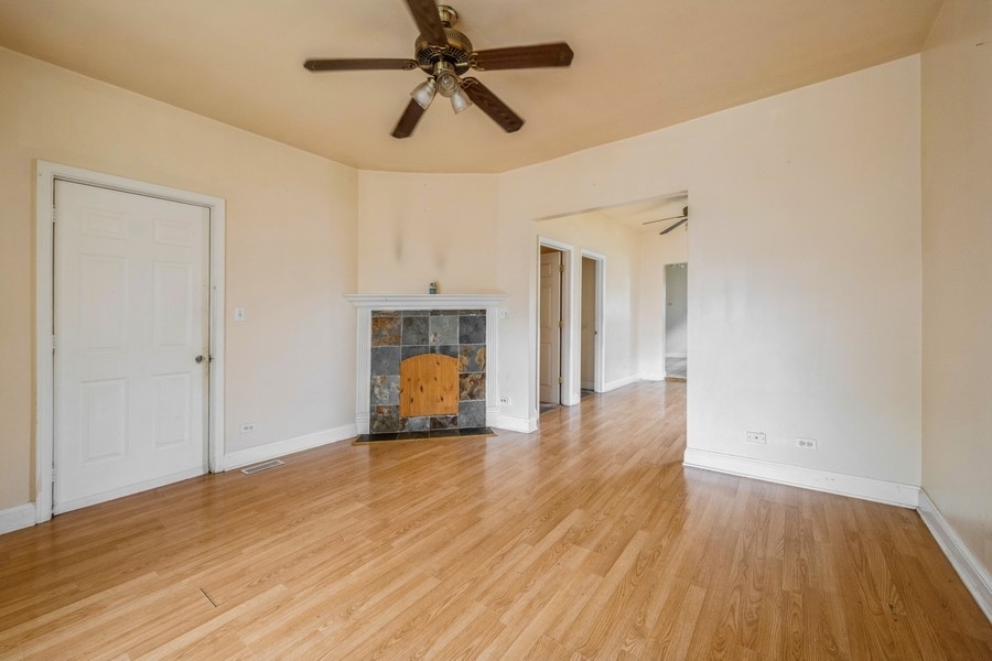 2139 North Kenneth Avenue Chicago, IL 60639 - Photo 2 of 21 a view of empty room with wooden floor and ceiling fan
