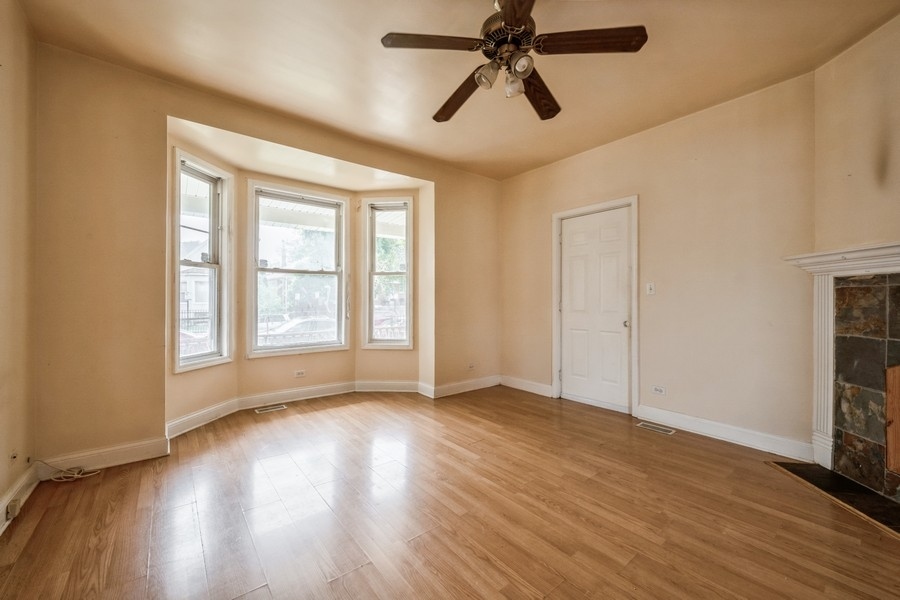 2139 North Kenneth Avenue Chicago, IL 60639 - Photo 3 of 21 a view of empty room with wooden floor and fan