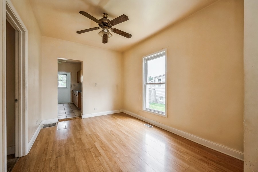 2139 North Kenneth Avenue Chicago, IL 60639 - Photo 4 of 21 a view of empty room with wooden floor and fan
