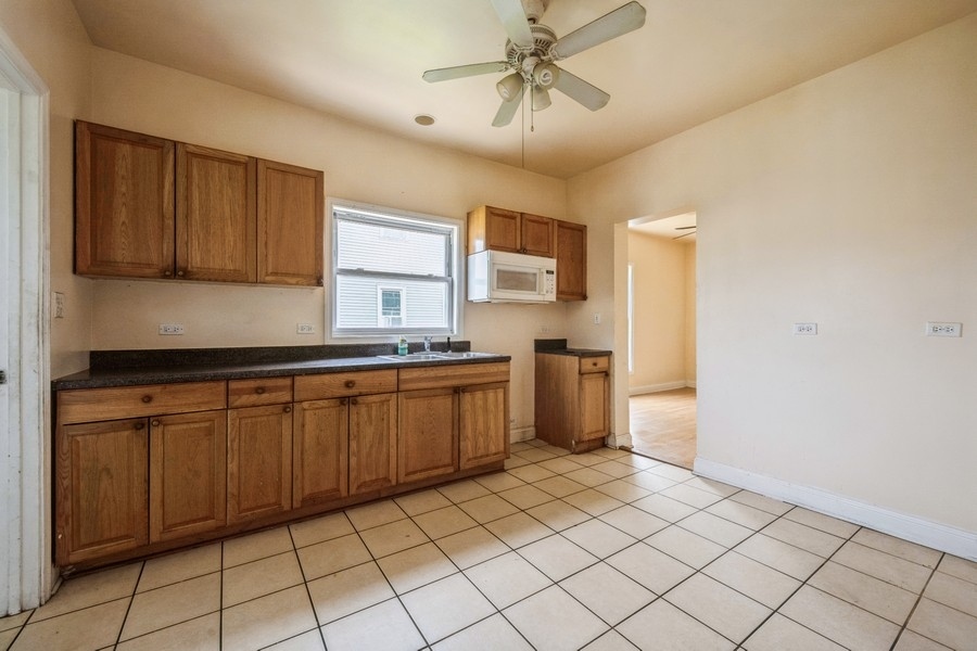 2139 North Kenneth Avenue Chicago, IL 60639 - Photo 7 of 21 a kitchen with a sink window and cabinets