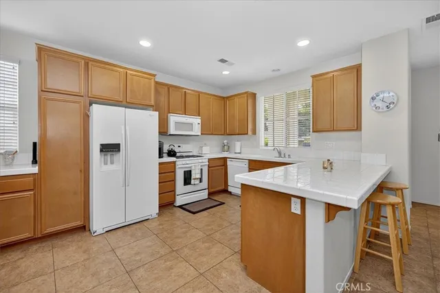 a kitchen with a sink a counter top space stainless steel appliances and cabinets