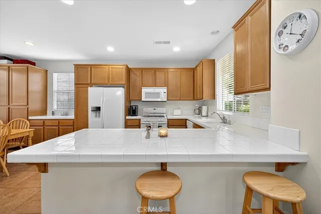 a kitchen with stainless steel appliances a sink a stove a refrigerator a counter top space and cabinets