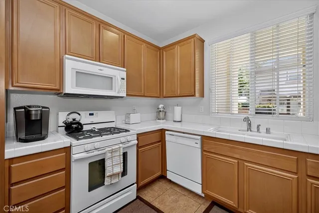 a kitchen with stainless steel appliances granite countertop a sink a stove and cabinets