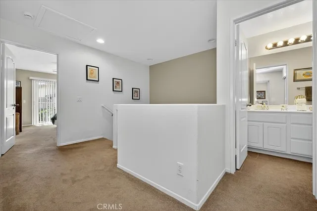 a view of a hallway with bathroom and mirror