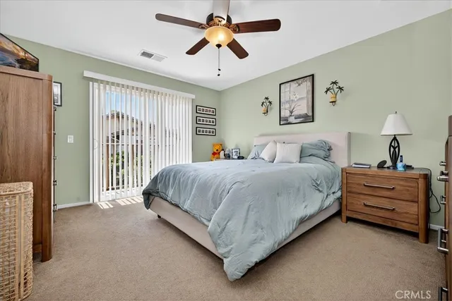 a spacious bedroom with a bed and a chandelier