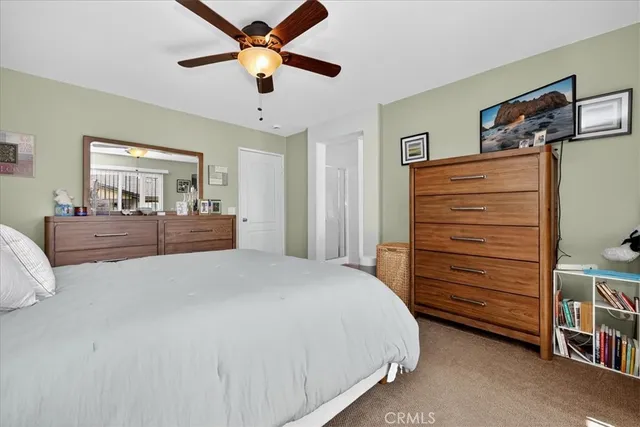 a bedroom with a bed and a ceiling fan