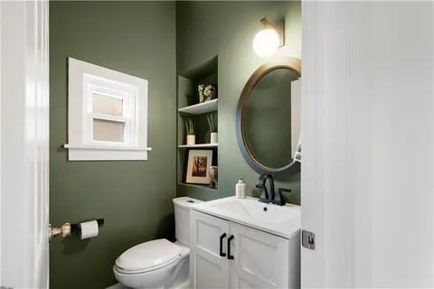 a bathroom with a toilet sink and mirror