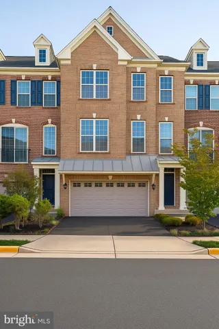 a front view of a building with a garden and plants