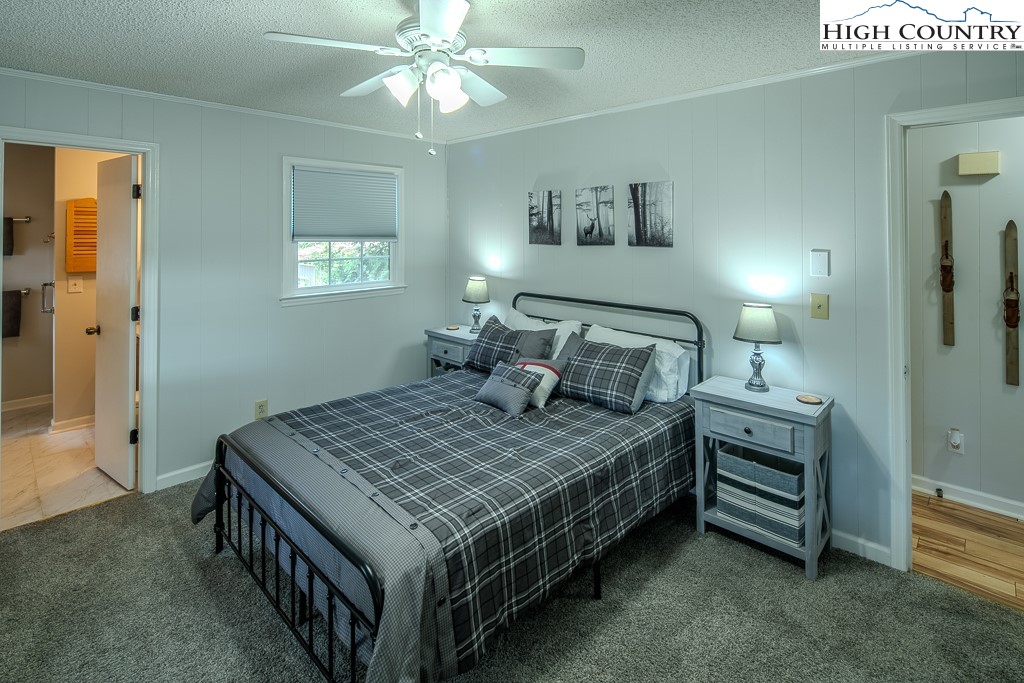 198 Black Pine Road Newland, NC 28657 - Photo 19 of 34 a bedroom with a bed and a chandelier
