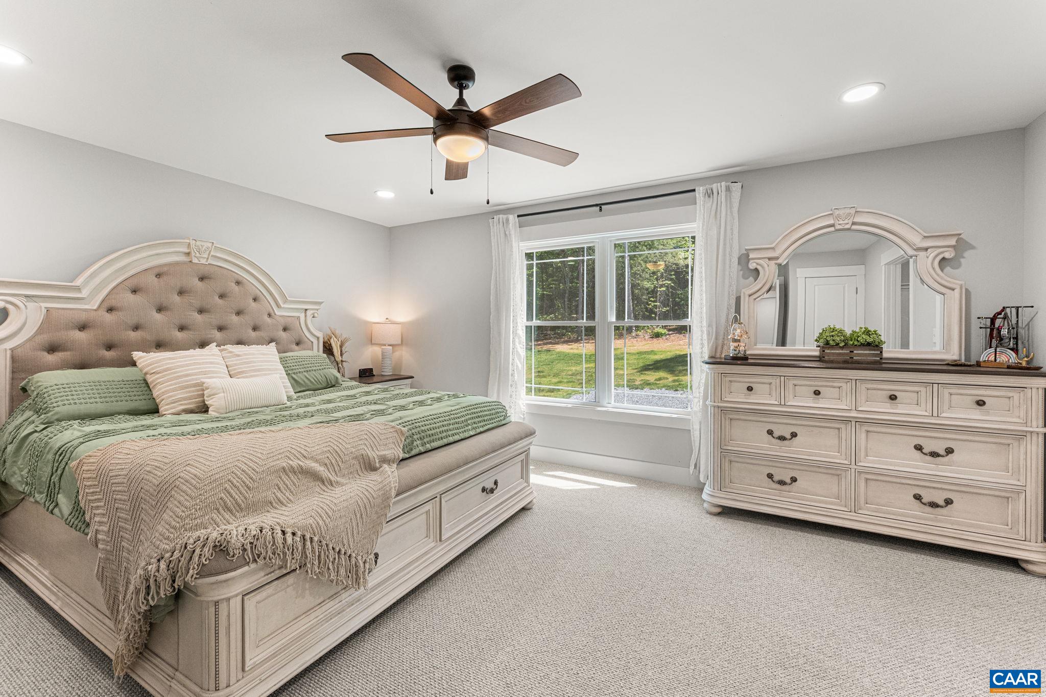 230 Fox Hollow Road Ruckersville, VA 22968 - Photo 22 of 42 a bedroom with a large bed and a chandelier