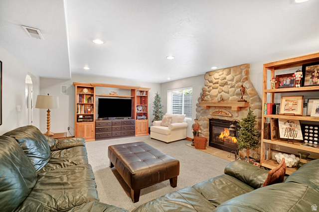 2139 Village Point Way Sandy, UT 84093 - Photo 21 of 35 Spacious recreation room featuring a stone-clad heatilator fireplace with a welcoming mantle.