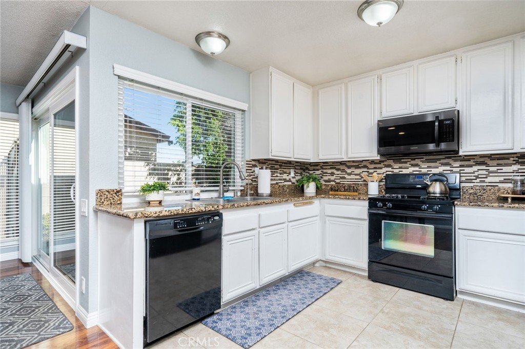 9121 Helms Avenue Rancho Cucamonga, CA 91730 - Photo 11 of 43 a kitchen with stainless steel appliances granite countertop a stove top oven a sink dishwasher a refrigerator and a microwave oven with a dishwasher