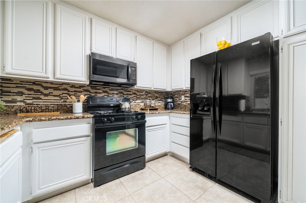 9121 Helms Avenue Rancho Cucamonga, CA 91730 - Photo 12 of 43 a kitchen with stainless steel appliances white cabinets and a stove a refrigerator with wooden floor
