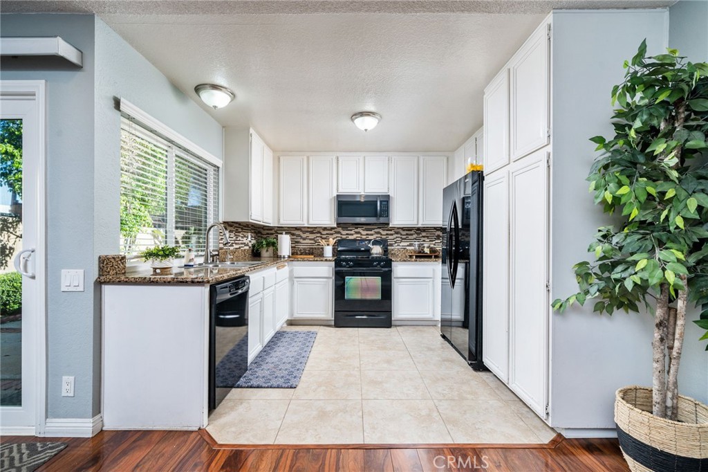 9121 Helms Avenue Rancho Cucamonga, CA 91730 - Photo 10 of 43 a kitchen with granite countertop a refrigerator and a sink