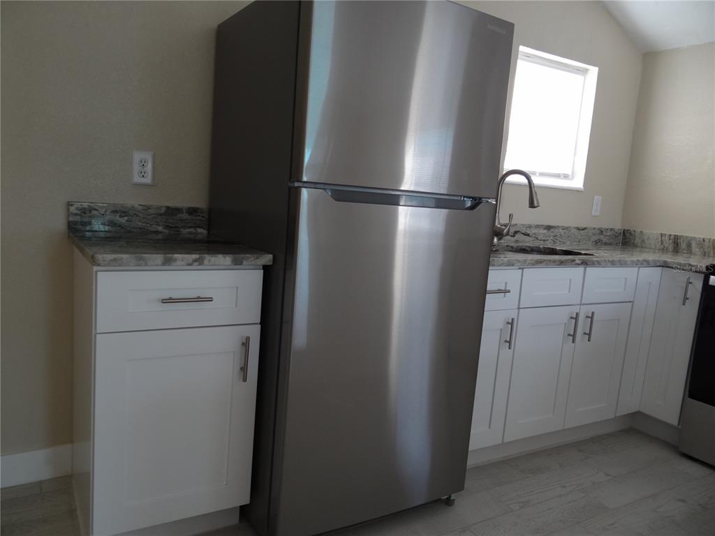 13360 Boca Ciega Avenue Madeira Beach, FL 33708 - Photo 11 of 45 a kitchen with a refrigerator and cabinets