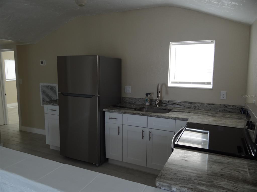 13360 Boca Ciega Avenue Madeira Beach, FL 33708 - Photo 12 of 45 a kitchen with granite countertop a refrigerator and a sink