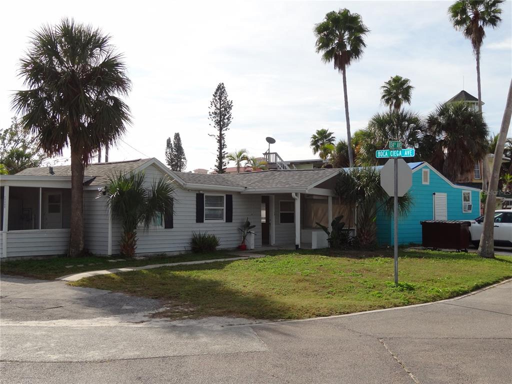 13360 Boca Ciega Avenue Madeira Beach, FL 33708 - Photo 3 of 45 a view of a house with a yard and palm trees
