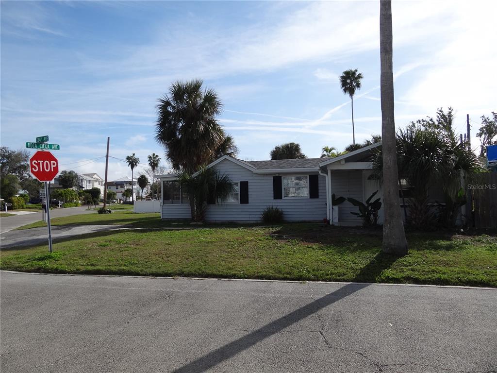 13360 Boca Ciega Avenue Madeira Beach, FL 33708 - Photo 39 of 45 a front view of a house with a garden and trees