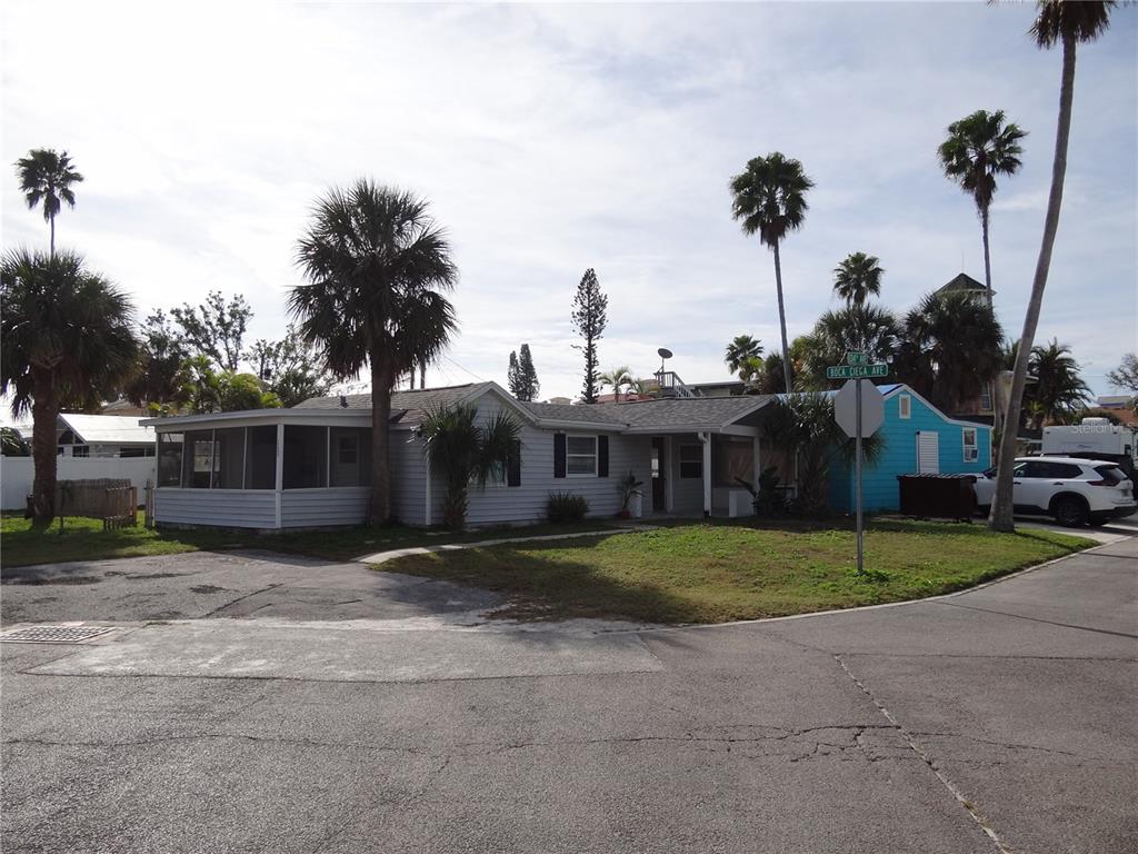 13360 Boca Ciega Avenue Madeira Beach, FL 33708 - Photo 40 of 45 a view of a house with a yard and palm trees
