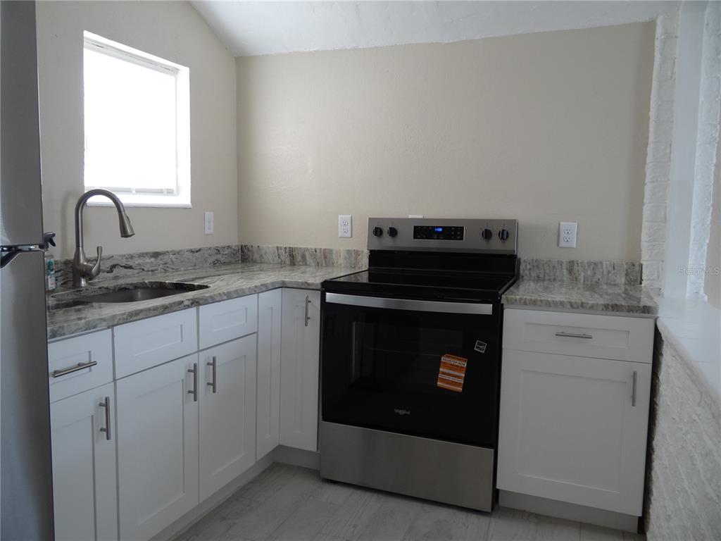 13360 Boca Ciega Avenue Madeira Beach, FL 33708 - Photo 9 of 45 a stove top oven sitting inside of a kitchen