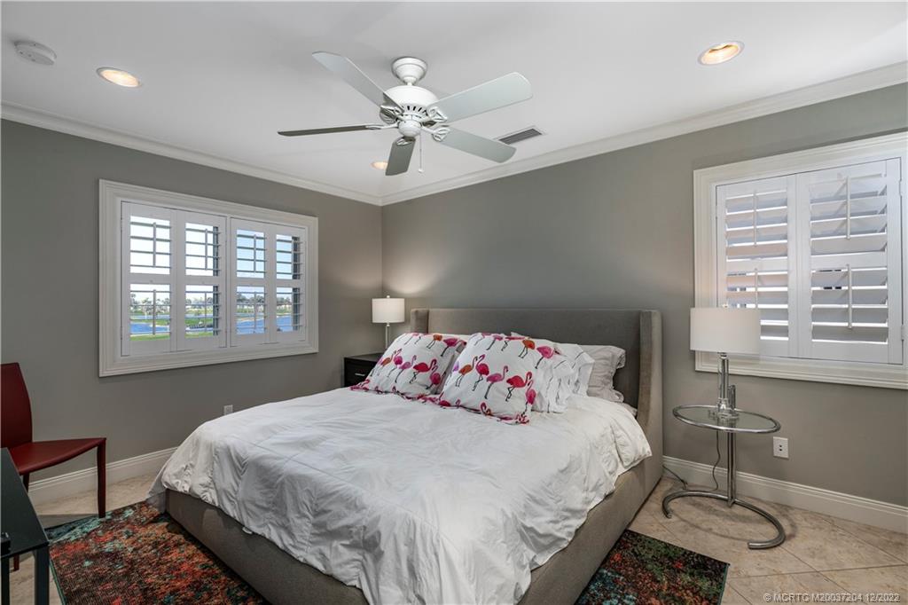 484 Northeast Plantation Road, Unit 4108 Stuart, FL 34996 - Photo 17 of 25 a bedroom with a bed and a table