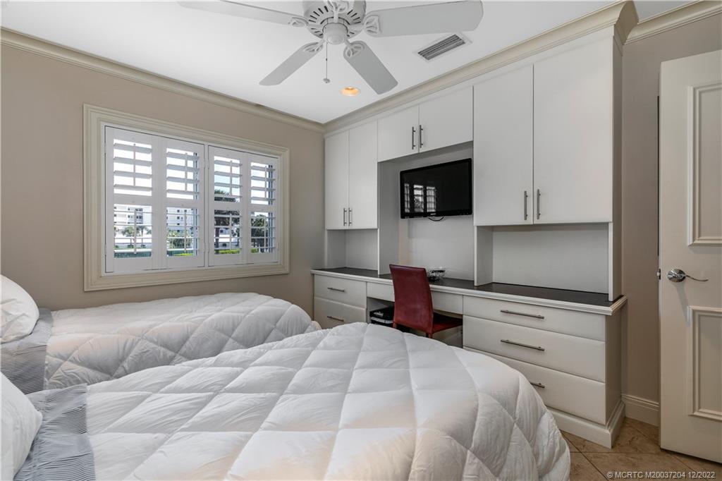 484 Northeast Plantation Road, Unit 4108 Stuart, FL 34996 - Photo 20 of 25 a bedroom with a large bed and a flat screen tv