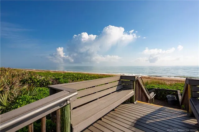 a view of a balcony with wooden floor and outdoor seating