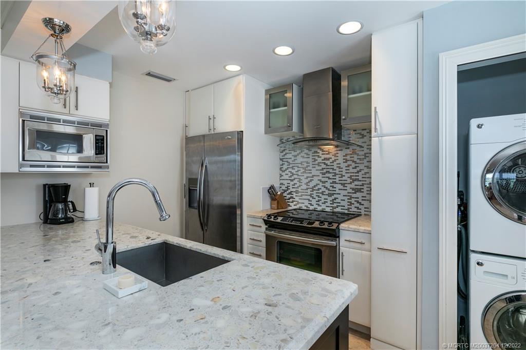 484 Northeast Plantation Road, Unit 4108 Stuart, FL 34996 - Photo 8 of 25 a kitchen with stainless steel appliances granite countertop a sink a stove and refrigerator