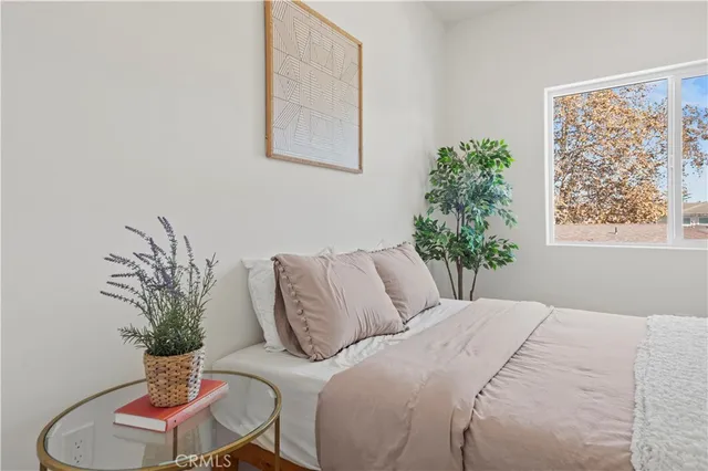 a bedroom with a large bed and a potted plant