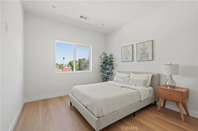 a bedroom with a bed and a painting on the wall