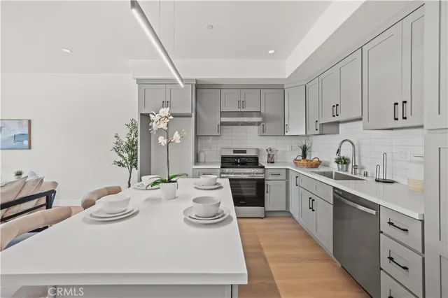 a kitchen with appliances a sink and cabinets