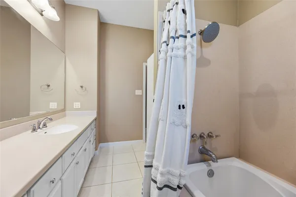 a bathroom with a tub a sink and mirror