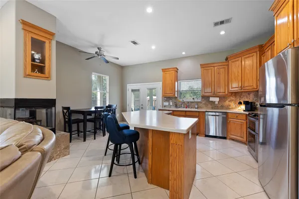 a kitchen with granite countertop wooden cabinets a counter top space and stainless steel appliances