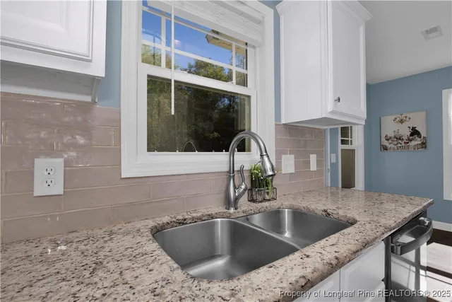 a kitchen with granite countertop a sink and a stove