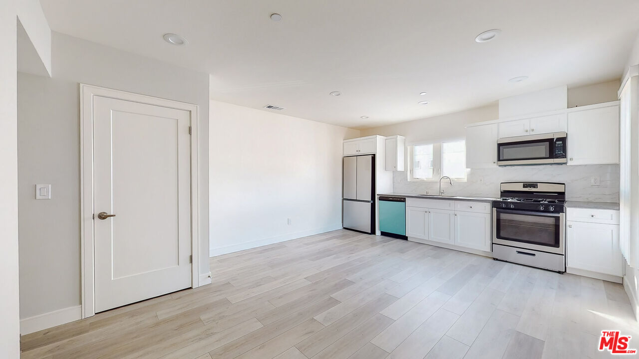 252 Rosemont Avenue, Unit 1/2 Los Angeles, CA 90026 - Photo 1 of 30 a view of a kitchen with a sink stove cabinets and empty room